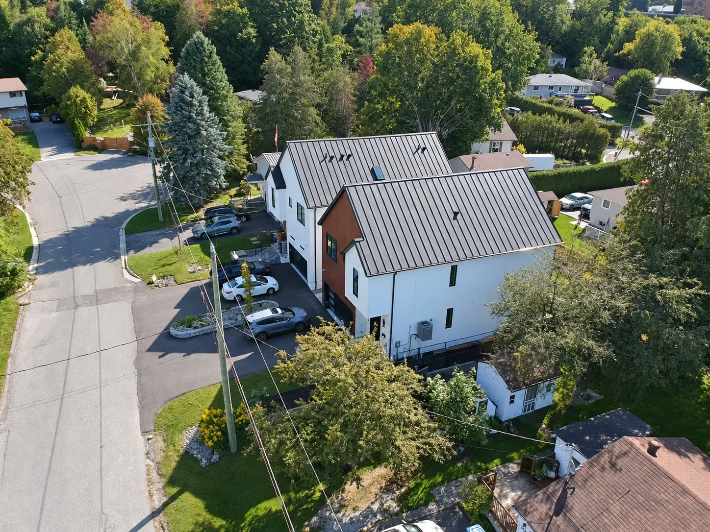 From the air over the street: the house and its neighbour with their driveways, the road at the left, the neighbourhood beyond