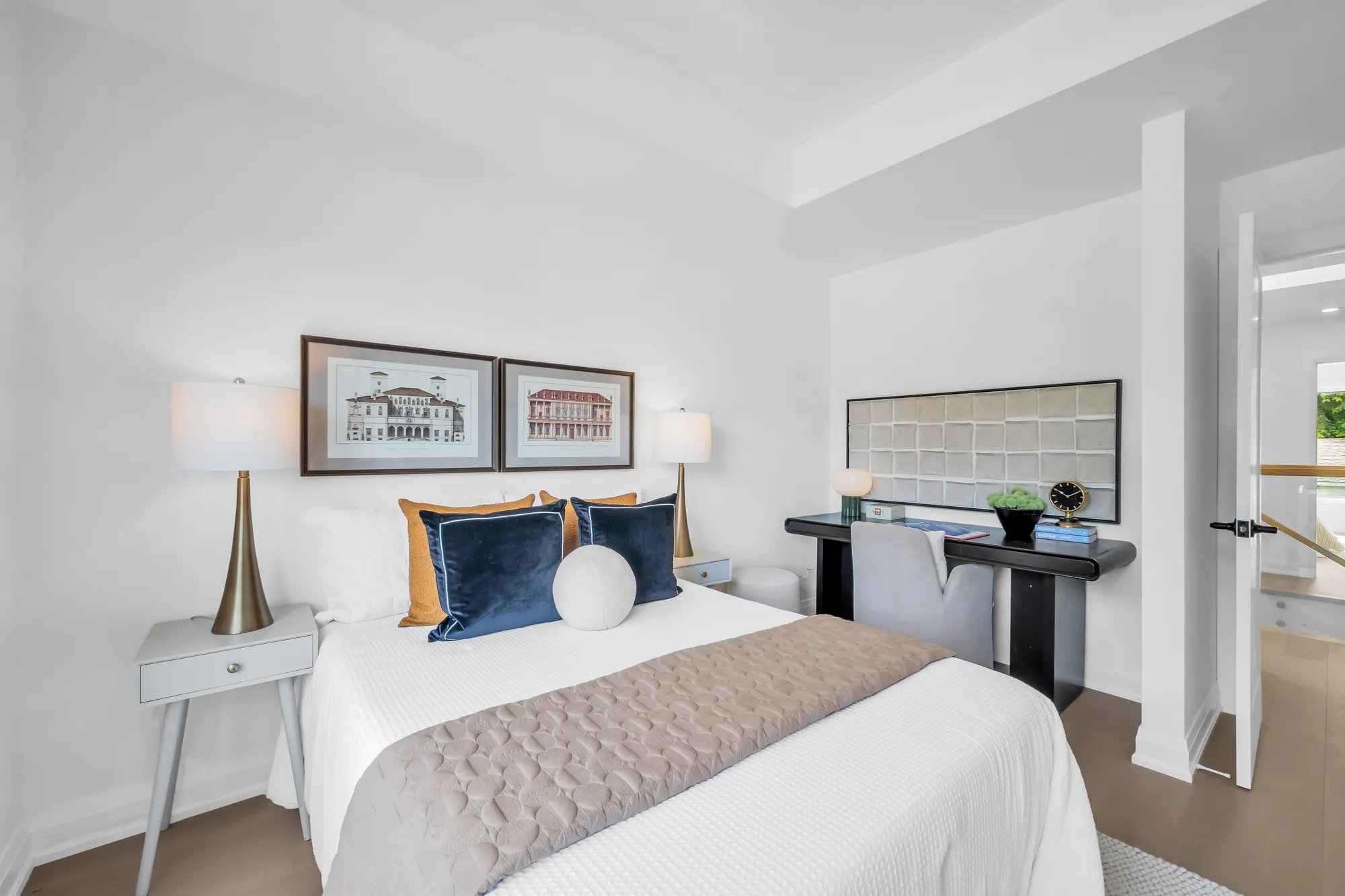 The third bedroom from the window: the bed and its prints, a white desk with a chair, the door