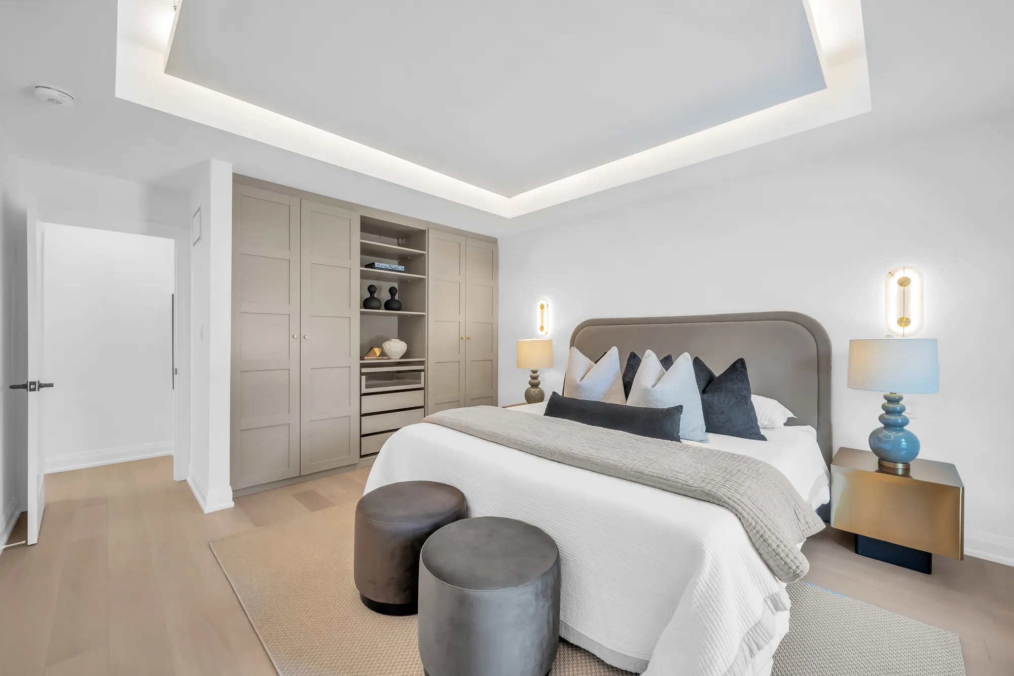 The fourth bedroom from the door: the bed, a wall of grey built-in wardrobes with open shelves, the window